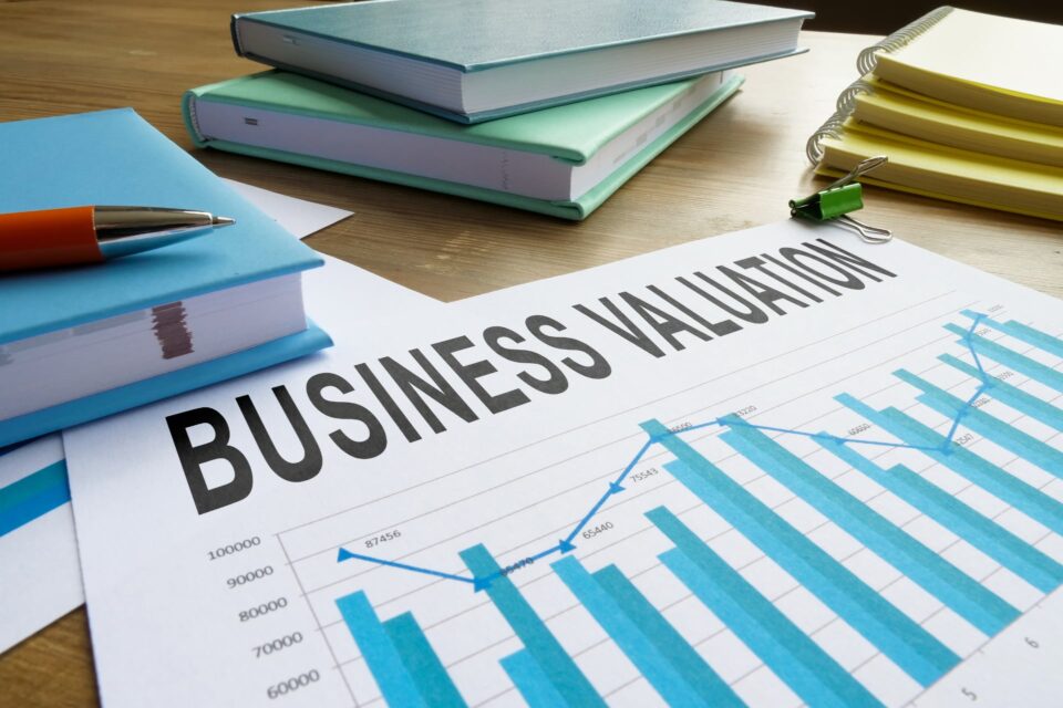 Business valuation report with a bar chart on a desk with notebooks and a pen
