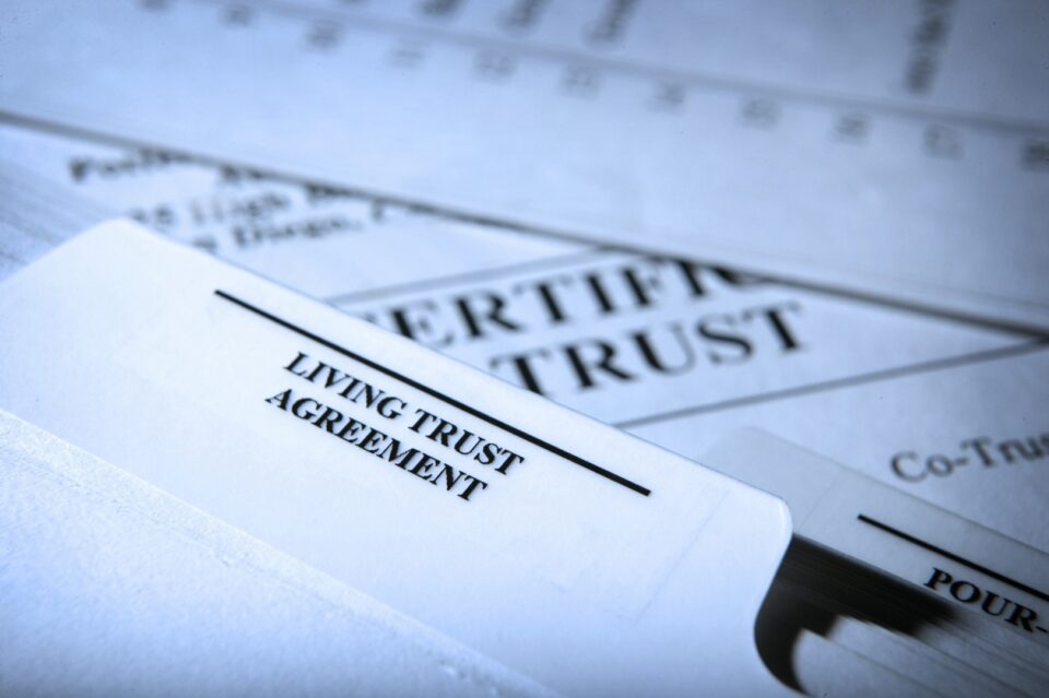Close-up of a Living Trust Agreement document with a pen